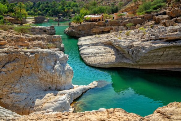 Wadi Bani Khalid in Oman with turquoise pools surrounded by rocky cliffs and palm trees