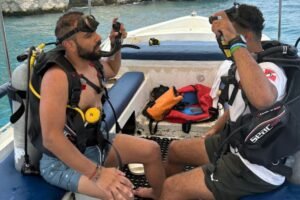 Scuba diving guide and tourist sitting together on a boat in Oman