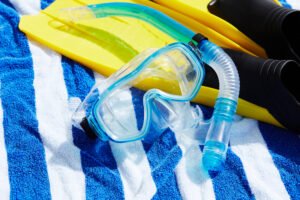 Essential snorkeling gear including a mask, snorkel, fins and towel