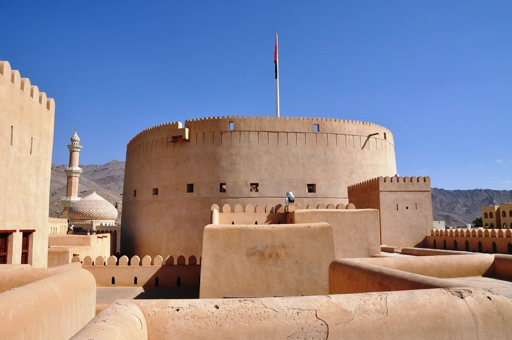 Nizwa Fort with its large circular tower and surrounding mountains in Oman