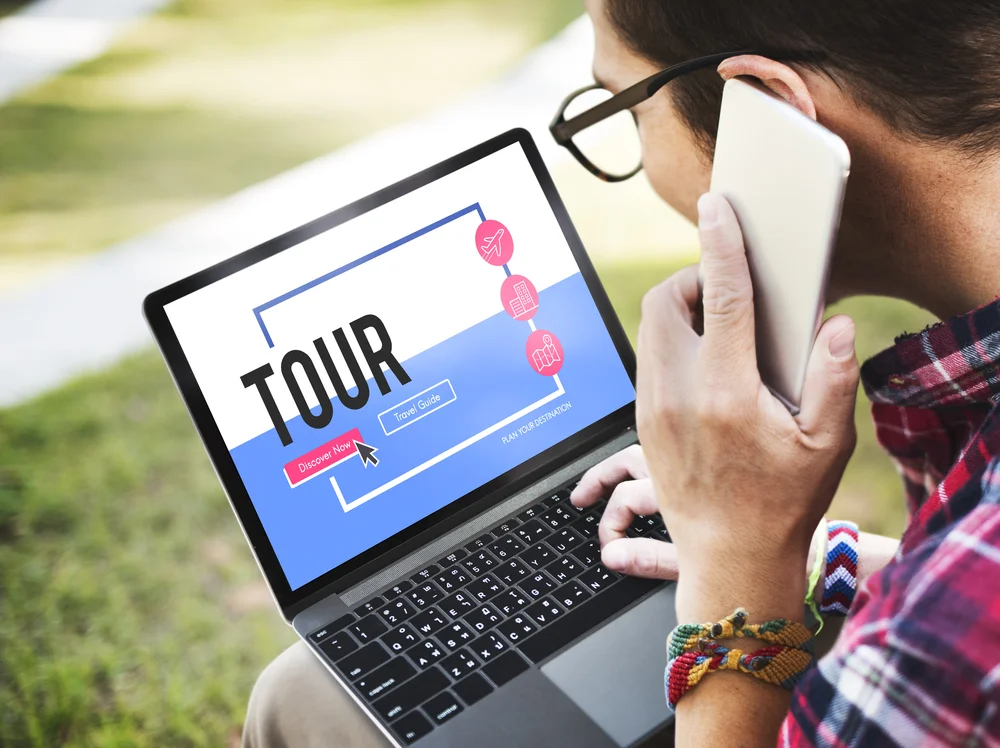 Traveler planning an Oman tour on a laptop and smartphone