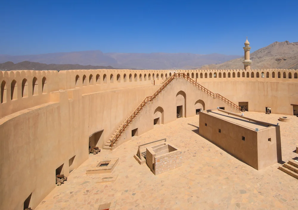 Historic Nizwa Fort with the Hajar Mountains in Oman